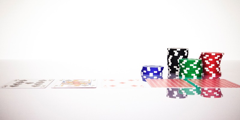 Playing cards and chips on a white table; JackpotCity Casino Blog