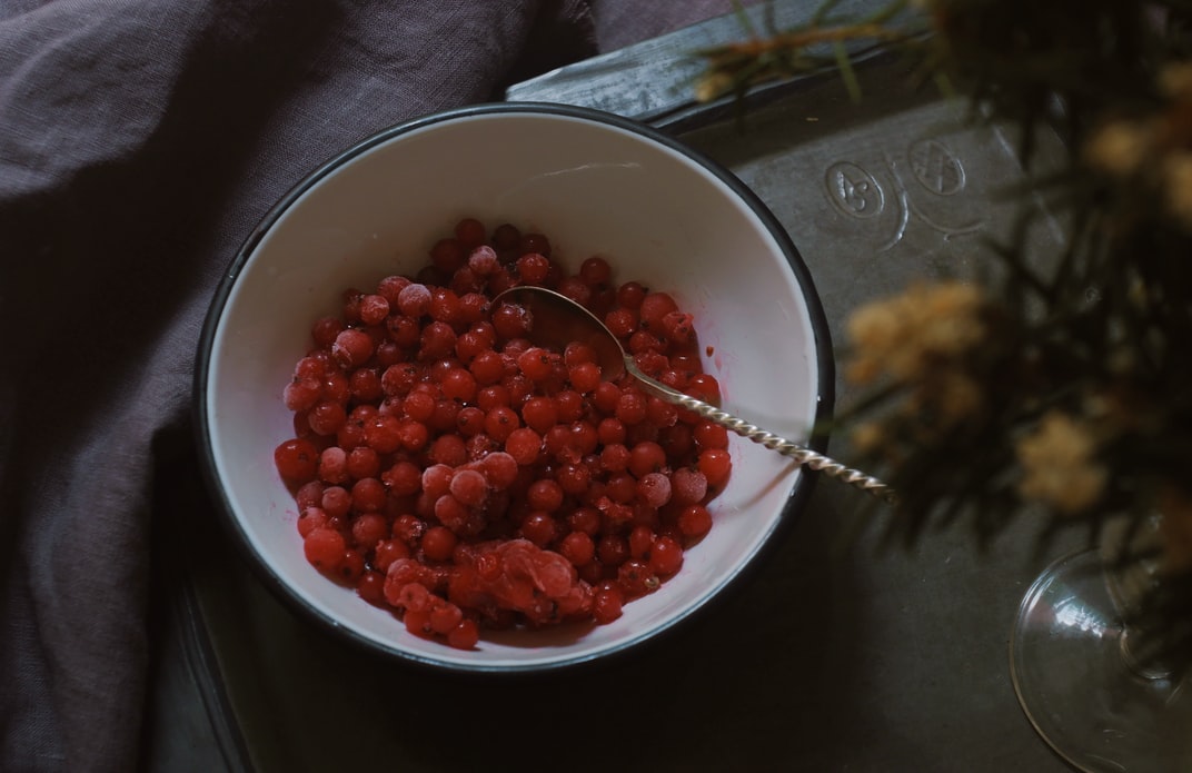 A bright red bowl of pomegranate seeds is one of many options to enjoy with an environmentally-friendly plant-based diet. 
