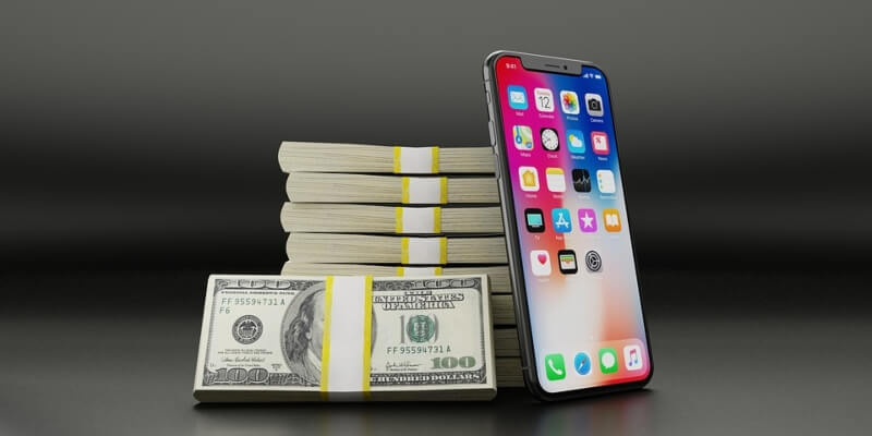 iPhone leaning against a stack of cash