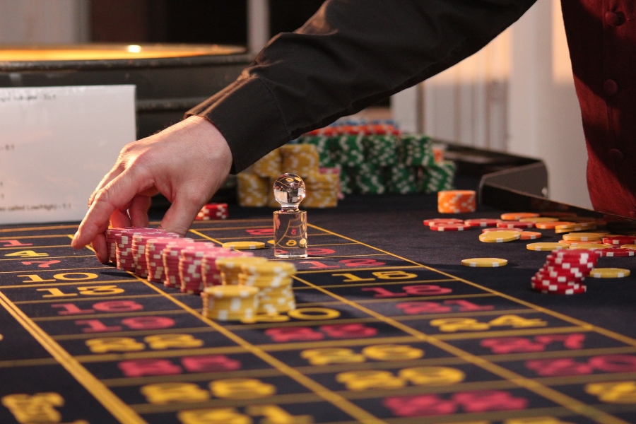 A dealer laying out casino chips on a Roulette table.