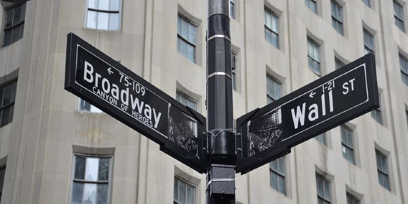 Street signs for Broadway and Wall Street
