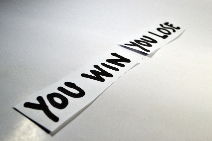 Two pieces of paper showing the words “You win” and “You lose”.