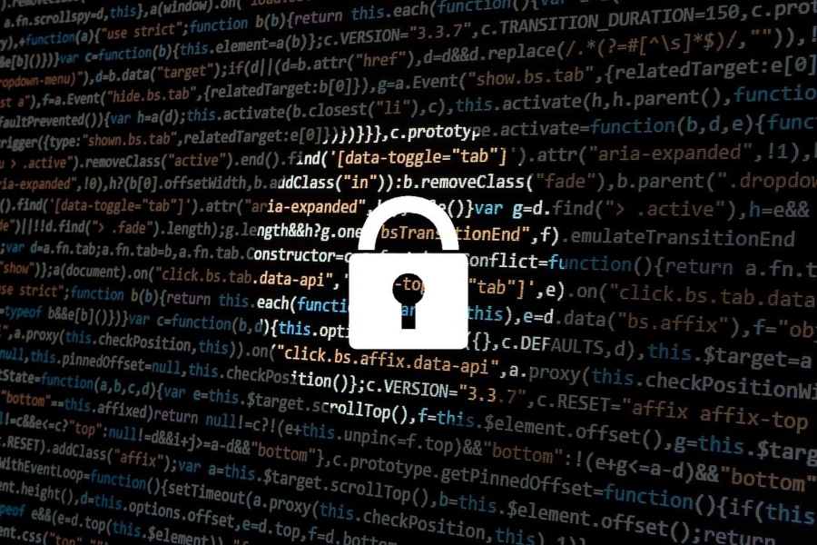 A cybersecurity padlock super-imposed over lines of computer code.