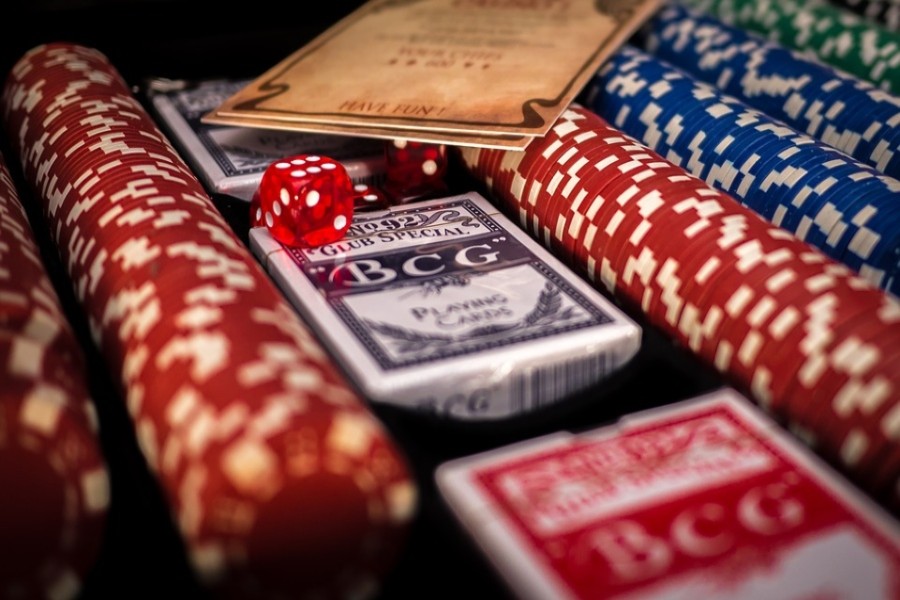 Playing cards, casino chips and dice lined up in a case.