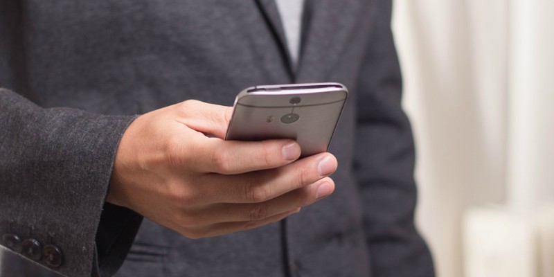 Man in a suit holding a mobile phone