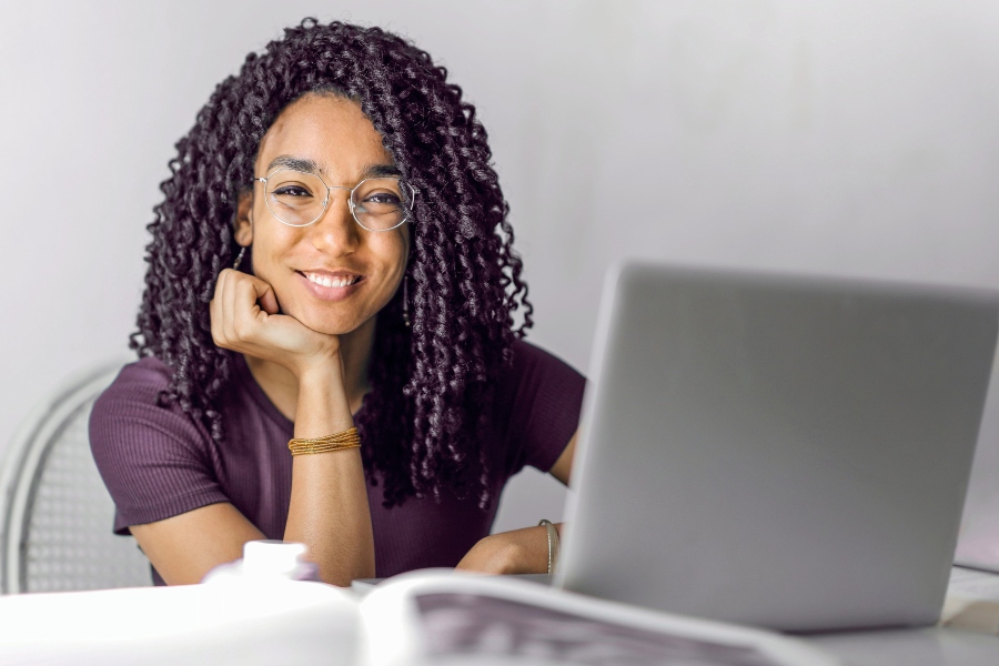 A young woman smiling while using a laptop