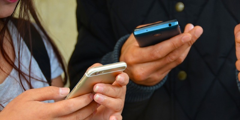 Two people holding smartphones