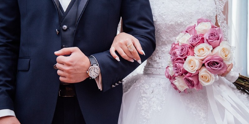 Bride and groom arm in arm with bouquet