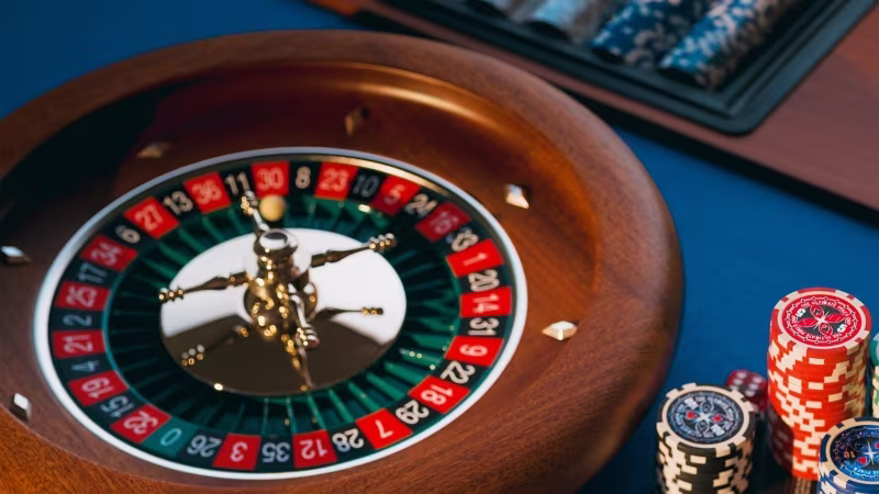 Wood Roulette wheel with casino chips on the side